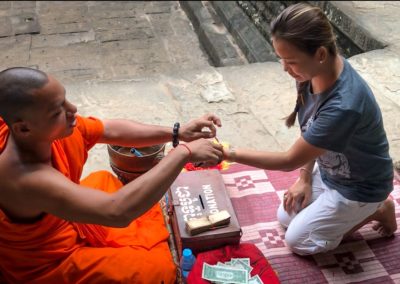 Viv receiving a blessing from a holy monk in Cambodia